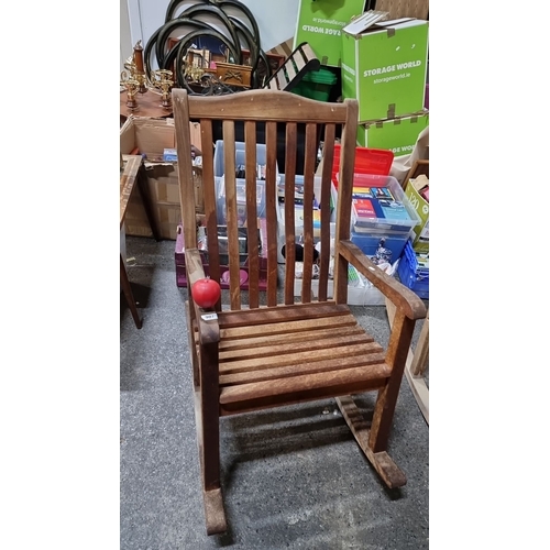 907 - A Vintage wooden rocking chair with slatted back, crafted from solid wood.