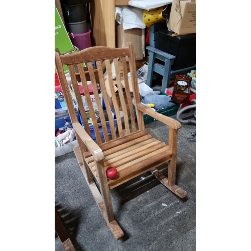 908 - A large Wooden rocking chair, crafted from natural wood, featuring vertical slat backrest and curved... 