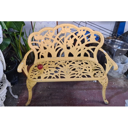 919 - Star lot ;A Victorian-style cast iron garden bench with intricate floral motif in vibrant yellow fin... 