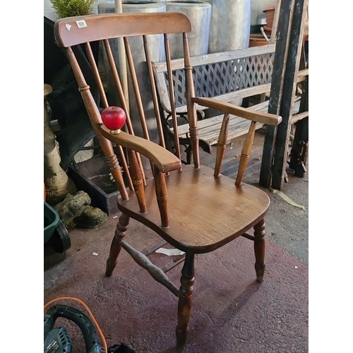 929 - An Oak Windsor armchair with spindle back and turned legs with repairs underneath .