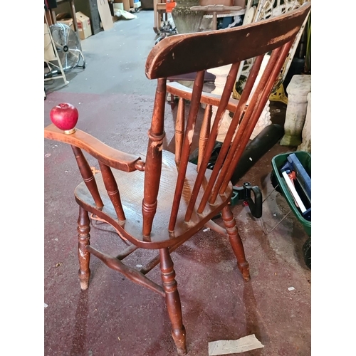 929 - An Oak Windsor armchair with spindle back and turned legs with repairs underneath .