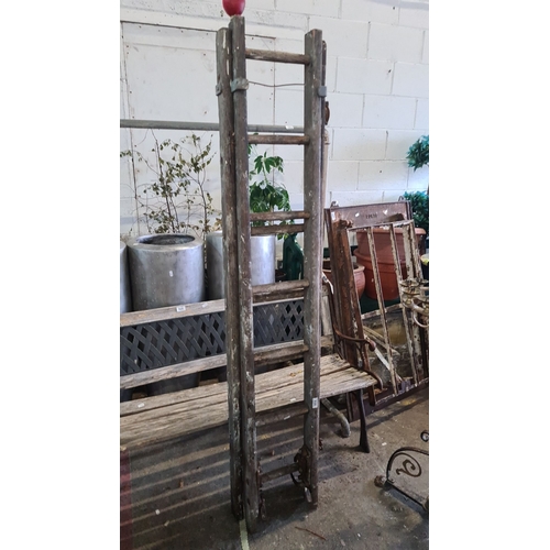 930 - A Vintage wooden ladder with metal fixtures, showcasing a rustic design from the early to mid 20th c... 