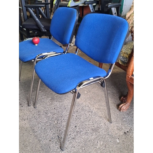 936 - Pair of blue-upholstered office chairs with chrome metal frames, featuring a simple, stackable desig... 