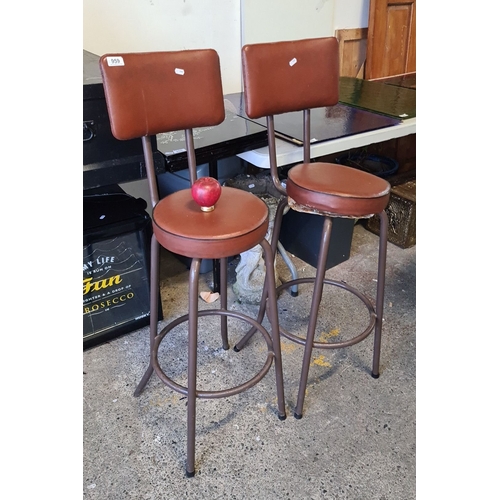 959 - Pair of vintage brown leather bar stools with metal frames, round seats, and backrests. Mid-century ... 