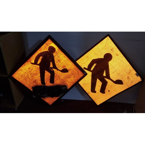 972 - Set of two vintage roadwork signs feature bold black figures on reflective orange backgrounds.