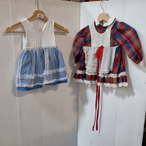 974 - Two vintage dresses: one plaid with lace trim, one white with blue skirt and heart embellishment.