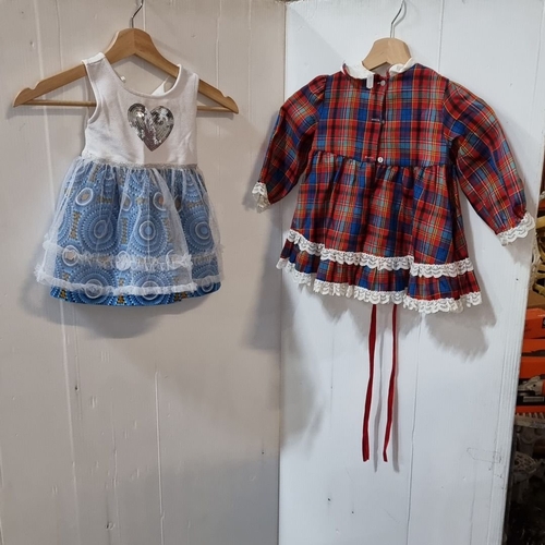 974 - Two vintage dresses: one plaid with lace trim, one white with blue skirt and heart embellishment.