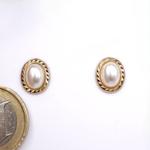 1079 - A classic pair of gold and pearl earrings. Total Weight: 0.6 g