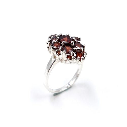 12 - A sterling silver garnet stone ring. Size - T 1/2. Weight - 8.2 grams.