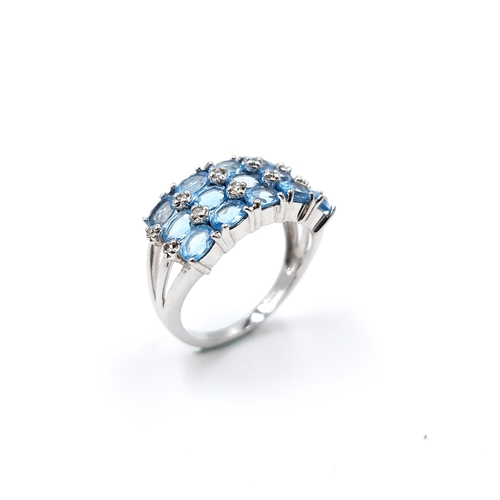 31 - A nine carat white gold ring set with blue topaz stone cluster mount with diamonds. Ring size - N. W... 