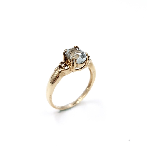 32 - Star Lot : An oval aquamarine stone ring with gem set accent to shoulders set in nine carat gold. Ri... 