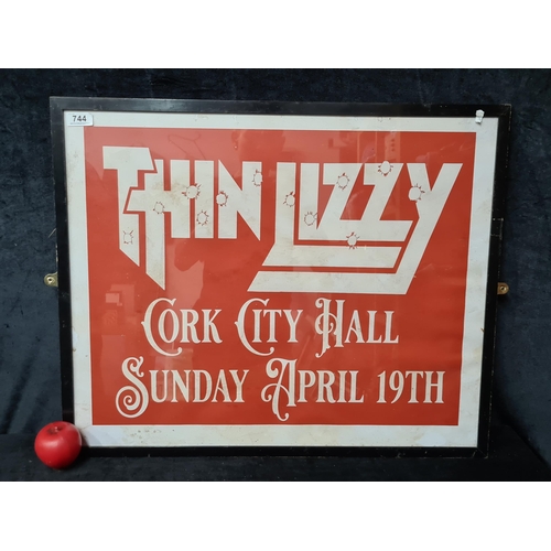 744 - A large print of a Thin Lizzy 'Cork City Hall' concert poster. Housed in a black frame behind glass.... 