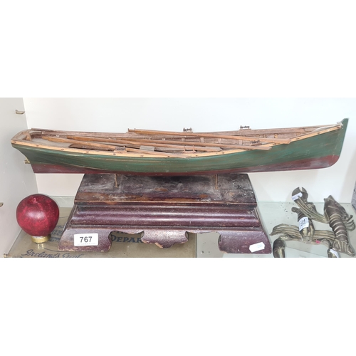 767 - A charming vintage handmade row boat complete with oars and mounted on a plinth base.