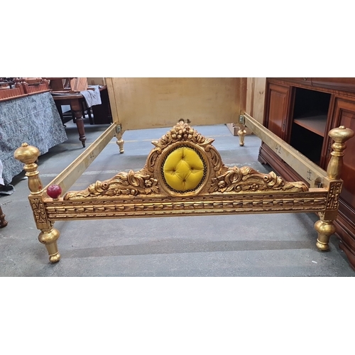 1189 - Star Lot : A majestic Gilded wooden bed frame featuring ornate detailing and plush yellow upholstery... 