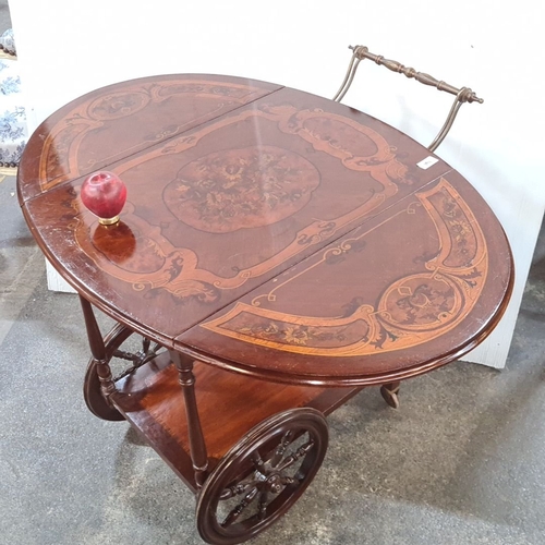 1192 - Star Lot : A very decorative tea trolley with inlaid floral marquetry, drop-leaf design, brass handl... 