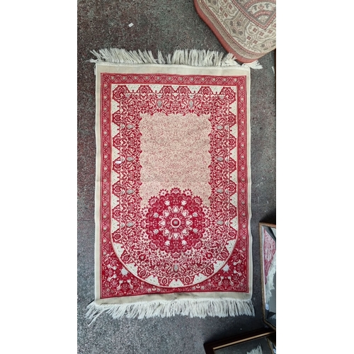 983 - Persian-style rug, featuring intricate red and bone floral patterns with fringe edges.