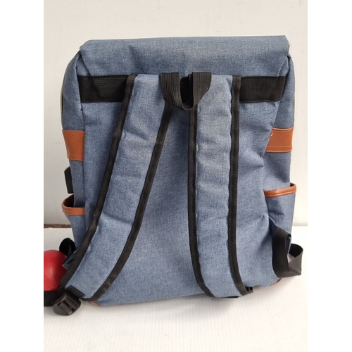 985 - Mancio denim backpack with leather accents features a front zipper pocket and adjustable straps. Sig... 