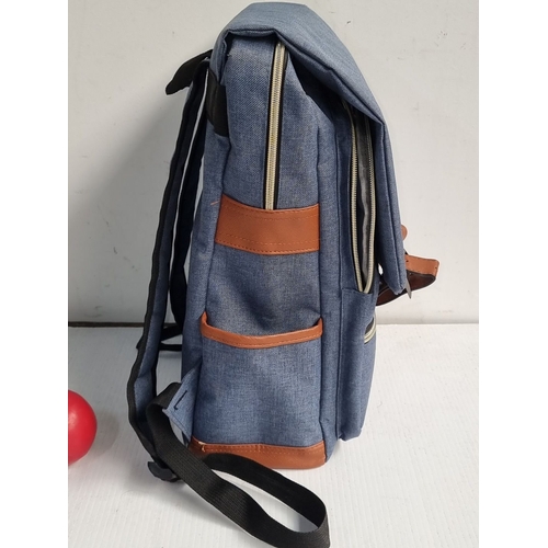 985 - Mancio denim backpack with leather accents features a front zipper pocket and adjustable straps. Sig... 