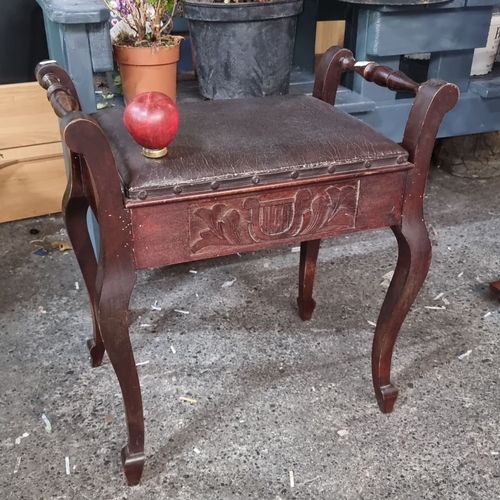 1207 - Mahogany piano stool with carved lyre motif, featuring a lift-up seat for storage, from the early 20... 