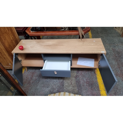 1315 - A good Modern Large Tv Stand  with oak veneer and grey doors. Includes three compartments and intern... 