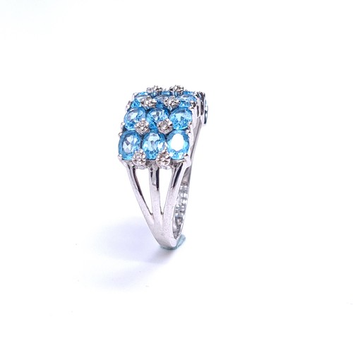 31 - A nine carat white gold ring set with blue topaz stone cluster mount with diamonds. Ring size - N. W... 