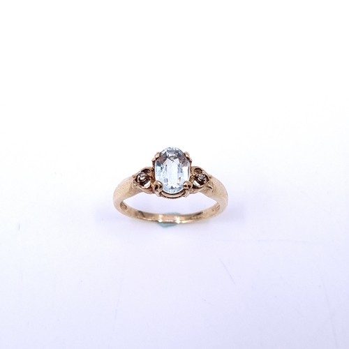 32 - Star Lot : An oval aquamarine stone ring with gem set accent to shoulders set in nine carat gold. Ri... 