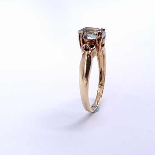 32 - Star Lot : An oval aquamarine stone ring with gem set accent to shoulders set in nine carat gold. Ri... 