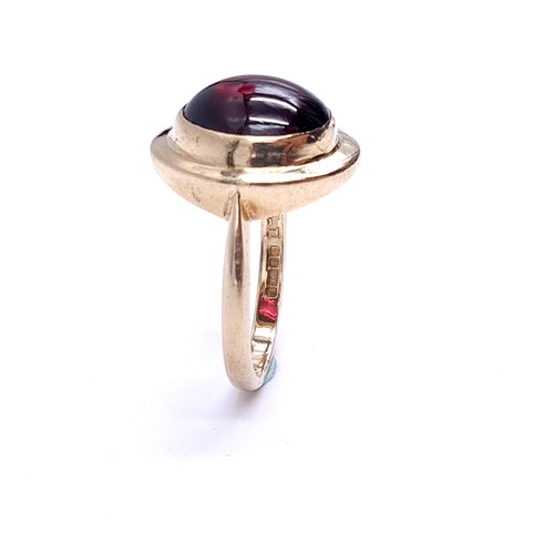 33 - An excellent example of a cabochon garnet stone ring set in nine carat gold. Ring size - P. Weight -... 