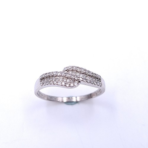 556 - Star Lot : A nine carat white gold single cut crossover ring. Est weight of diamonds - 0.25 carats. ... 