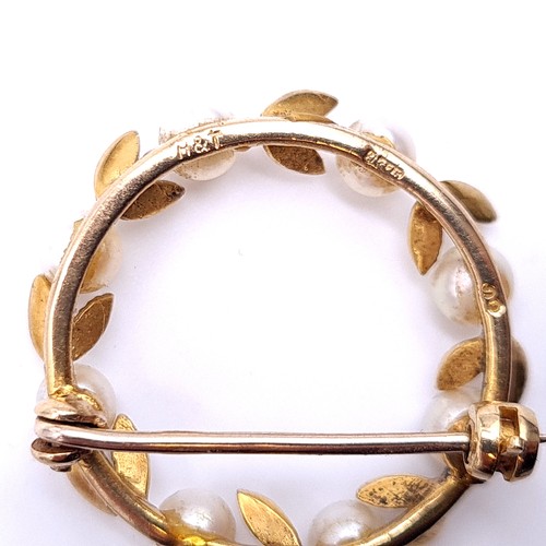 563 - A pretty nine carat gold (375) circular pearl leaf design brooch with safety chain. Marks to pun att... 