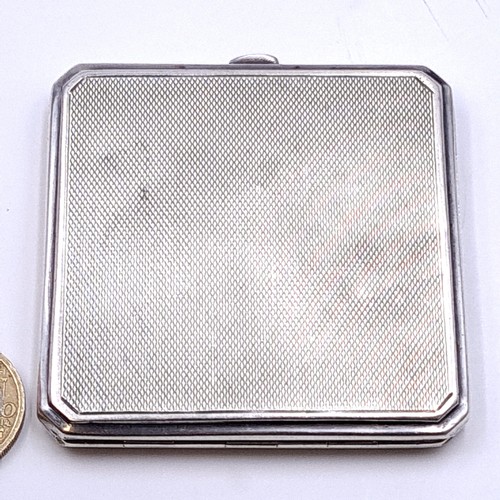 585 - A sterling silver hallmarked Birmingham glazed powder compact with machine cut detailing. Dimensions... 