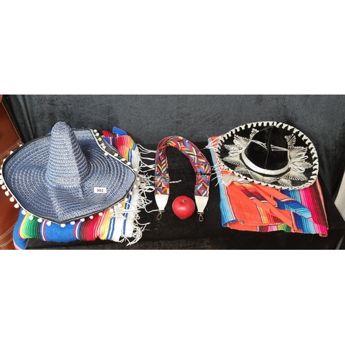 982 - An interesting lot of traditional Mexican attire. Features two sombreros and two vibrant ponchos and... 