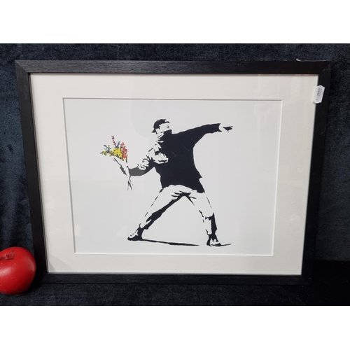 990 - A print after an original 'Banksy' titled 'Flower Thrower'. Housed in a black frame behind glass.