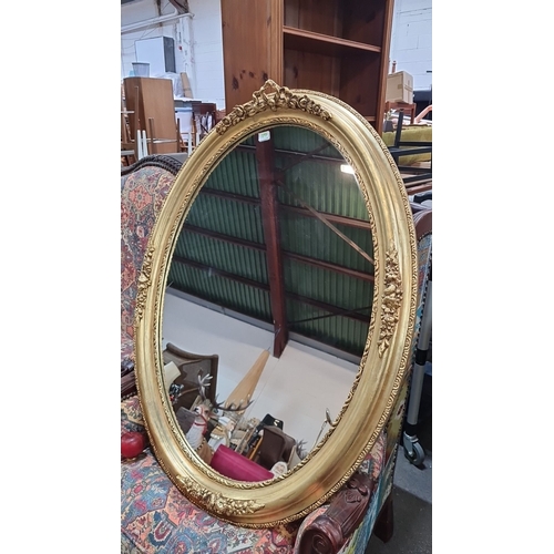 1197 - Star lot :  A Large Oval gilt mirror with ornate floral and ribbon detailing from the Victorian peri... 