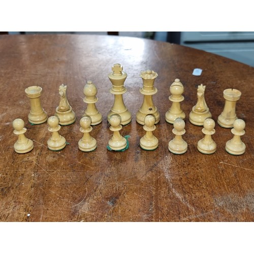 981 - A lovely set of carved wooden chess pieces housed in a neat wooden box with sliding lid.