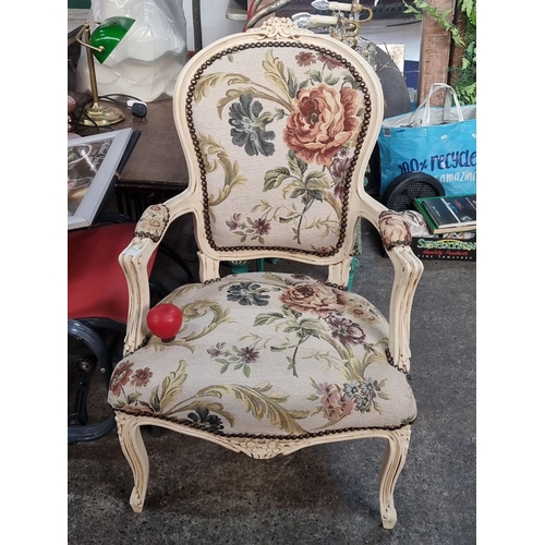 1205 - French-style upholstered armchair with floral tapestry and carved wood frame. Features pastel tones ... 