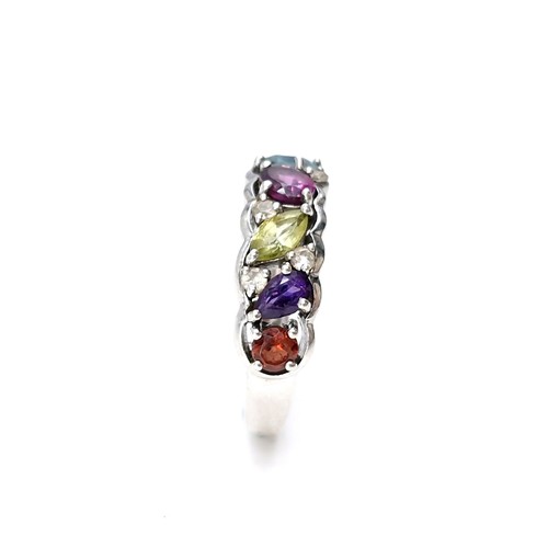 13 - A vari hue gemstone ring, with amethyst, aqua, citrine, sapphire etc  set in sterling silver. Ring s... 