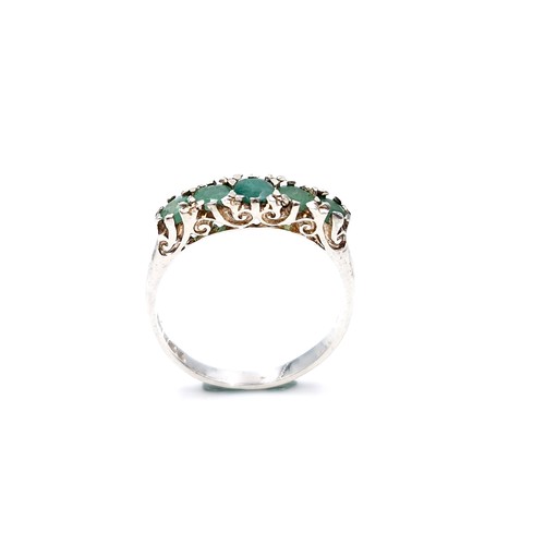 16 - A lovely five stone emerald ring set in sterling silver. Size - K. Weight - 1.6 grams.