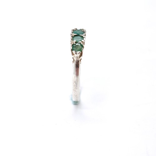 16 - A lovely five stone emerald ring set in sterling silver. Size - K. Weight - 1.6 grams.