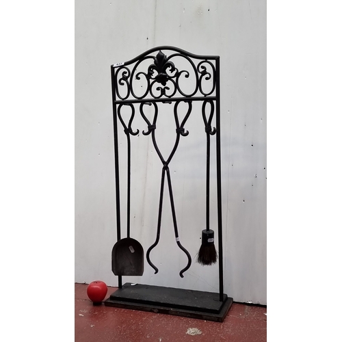 433 - Black wrought iron fireplace tool set featuring scrollwork and fleur-de-lis design. Includes shovel,... 