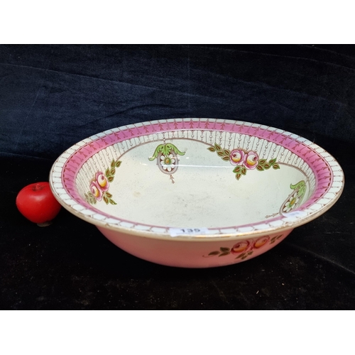 135 - A very large and highly impressive hand painted wash bowl, adorned with floral decoration in pastel ... 