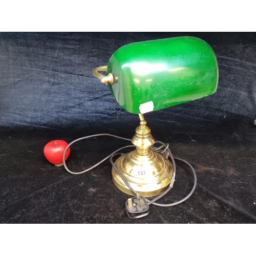 137 - An elegant and traditional bankers lamp featuring emerald green glass shade and brass base. In good ... 