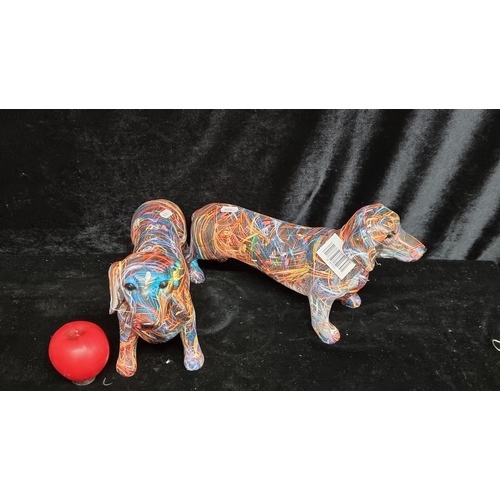 194 - A pair of large charming miniature dachshund figures in abstract fluorescent tones. Brand new from a... 