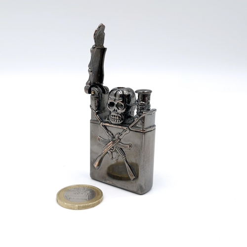 31 - A metal gas lighter set with a skull mount with crossed riffles. Dimensions: 6 x 3.5 cms. Weight - 6... 