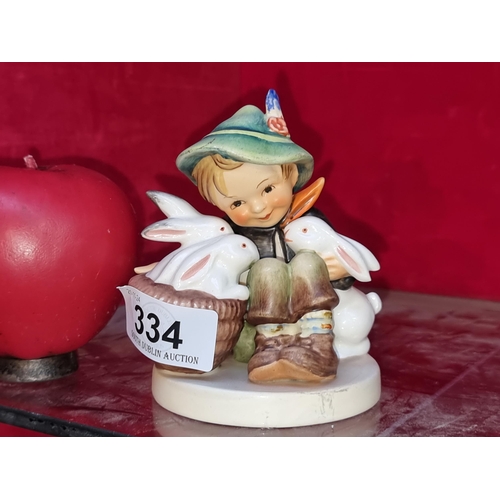 334 - A sweet Goebel Hummel West German figure of a young boy nestling up with his furry rabbit friends. I... 