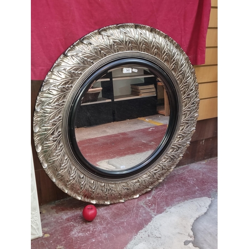 345 - A large bevelled mirror of circular form housed in a modern frame.