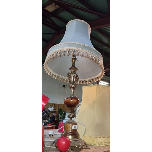 384 - An elegant large brass and turned wood column table lamp with floral and fringe design shade.