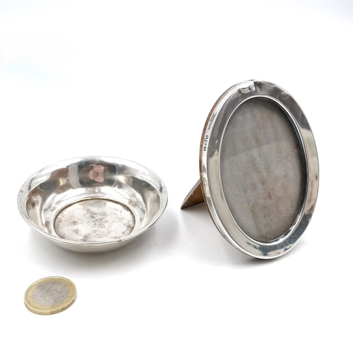 7 - Two sterling silver items - a glazed oval photograph frame hallmarked Sheffield with polished wood b... 