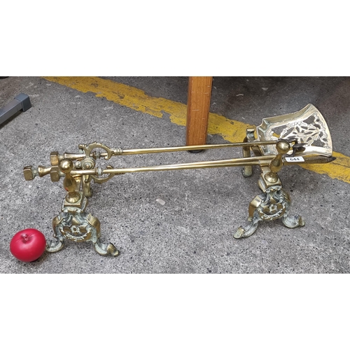 644 - Star Lot : An antique brass fireside companion set including fire dogs, poker, tongs and shovel. A l... 