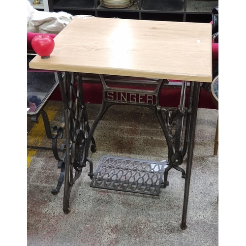 659 - A fabulous antique Singer sewing machine table mounted with a solid pine table top surface.